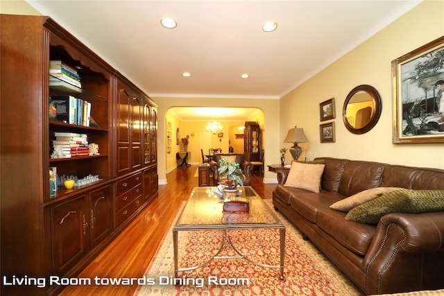 living area with arched walkways, a notable chandelier, wood finished floors, and recessed lighting