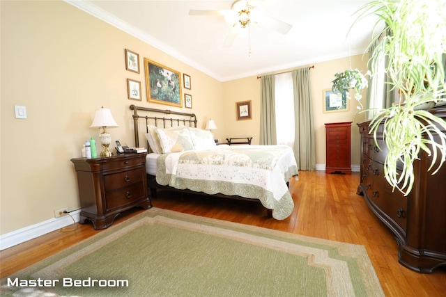 bedroom featuring ornamental molding, a ceiling fan, baseboards, and wood finished floors