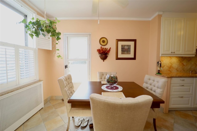 dining area with radiator heating unit, ornamental molding, and baseboards