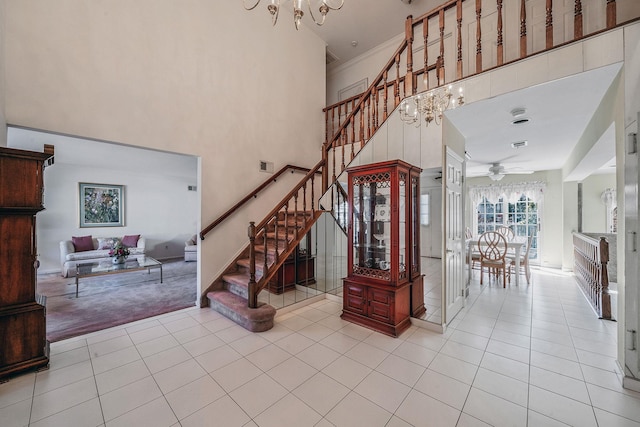 carpeted foyer with stairs, a high ceiling, visible vents, and tile patterned floors