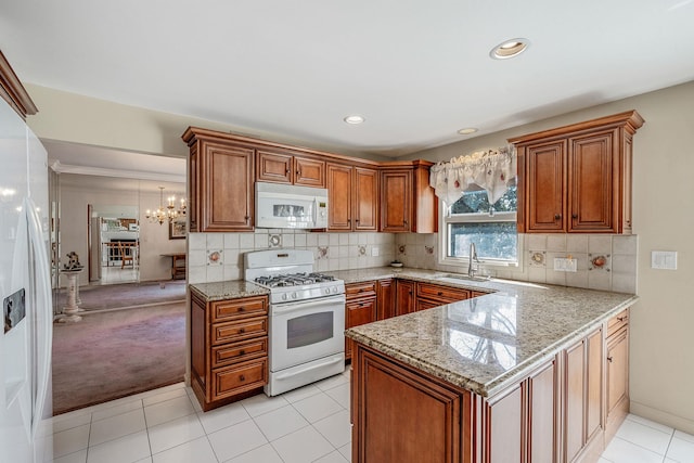 kitchen with brown cabinetry, white appliances, a sink, and a peninsula