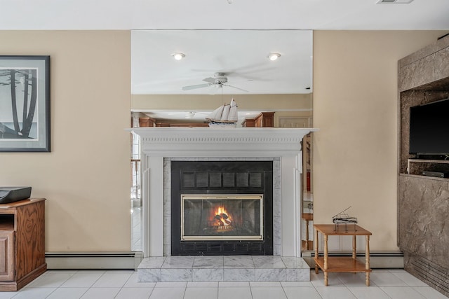 details featuring visible vents, a tile fireplace, ceiling fan, a baseboard radiator, and baseboard heating