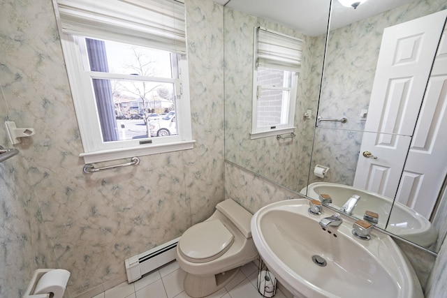 half bath featuring a baseboard radiator, a sink, and wallpapered walls