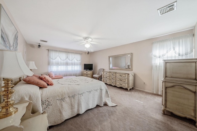 bedroom featuring a ceiling fan, visible vents, light carpet, and baseboards