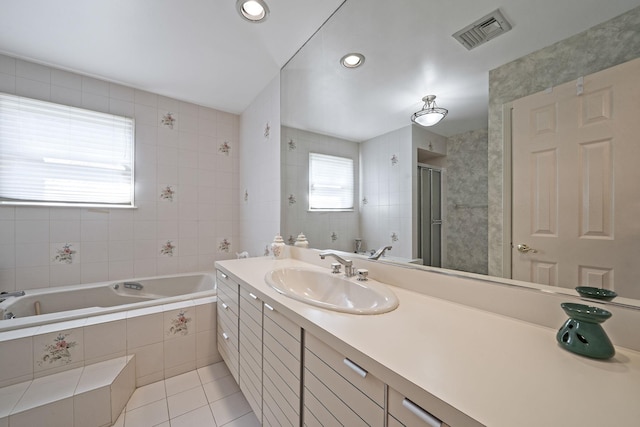 bathroom featuring vanity, visible vents, a shower stall, a bath, and tile patterned floors