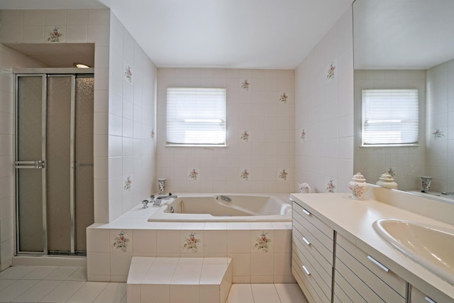 bathroom featuring a stall shower, vanity, tile walls, and a bath