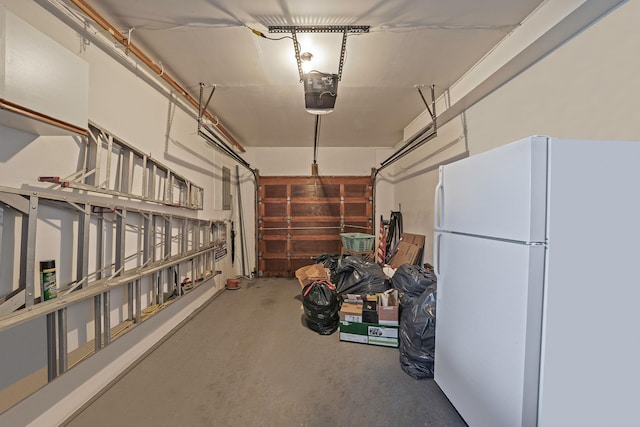 garage with a garage door opener and freestanding refrigerator