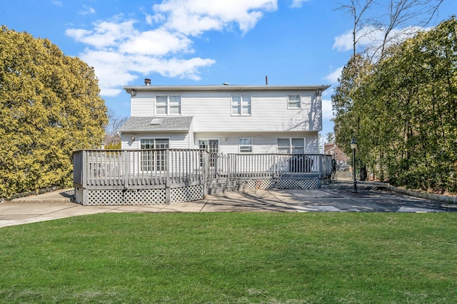 back of property with a deck and a yard