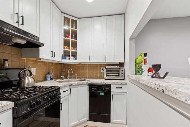 kitchen with a toaster, under cabinet range hood, a sink, white cabinetry, and black appliances