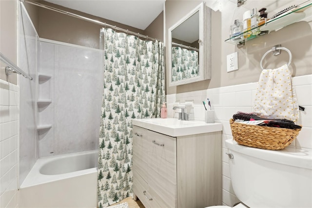 bathroom featuring a wainscoted wall, shower / tub combo with curtain, tile walls, toilet, and vanity