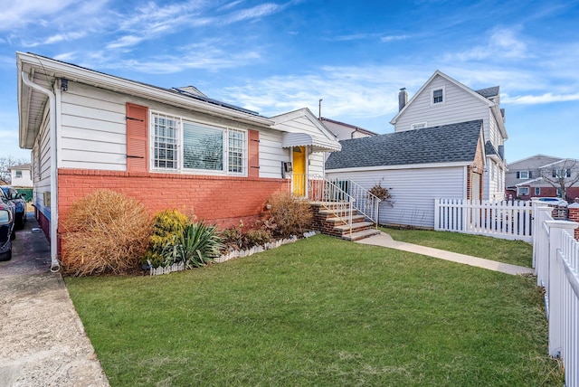 view of front of home with a front lawn, fence, and brick siding