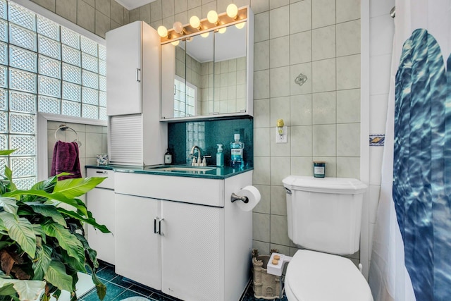 full bathroom with toilet, decorative backsplash, tile walls, and vanity