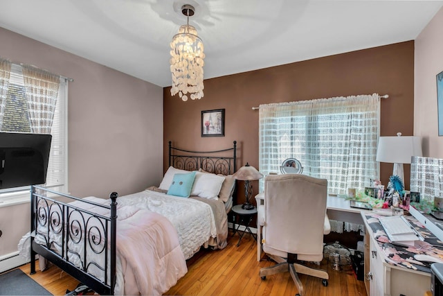 bedroom with an inviting chandelier and wood finished floors