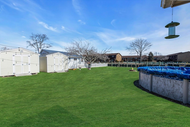 view of yard featuring an outbuilding, a shed, fence, and a fenced in pool