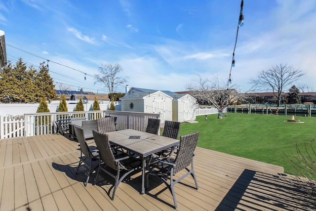 deck with a yard, outdoor dining area, an outdoor structure, and a fenced backyard