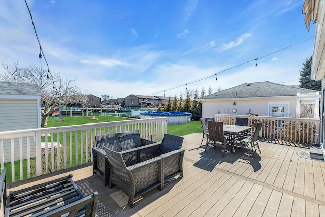 deck with outdoor lounge area, a lawn, and outdoor dining space