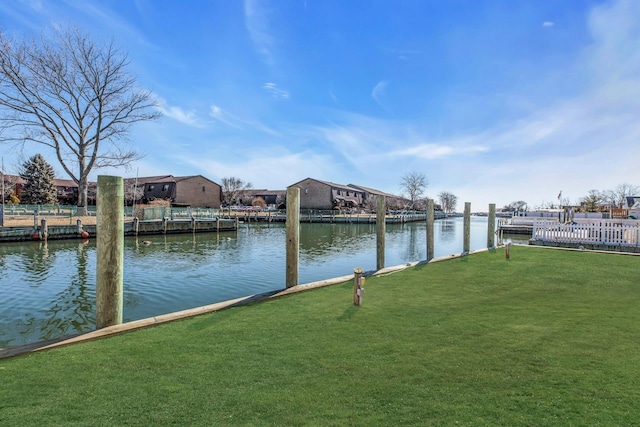 dock area with a water view and a lawn