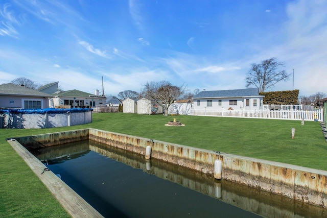 back of property featuring a fenced in pool, a yard, a storage unit, a fenced backyard, and an outdoor structure