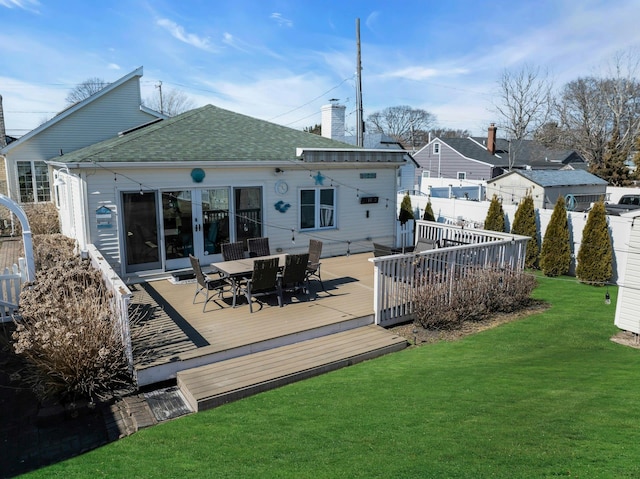 back of house with a chimney, a lawn, outdoor dining space, fence, and a deck