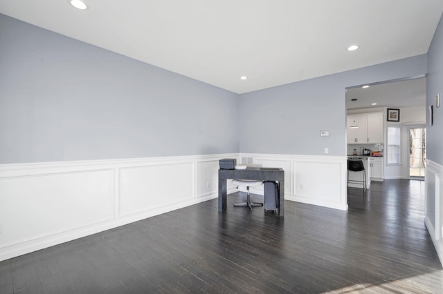 spare room with recessed lighting, dark wood-style floors, and a wainscoted wall