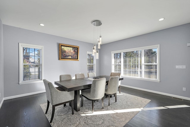 dining space with visible vents, a healthy amount of sunlight, dark wood-type flooring, and baseboards