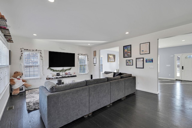 living area with dark wood finished floors, visible vents, recessed lighting, and baseboards