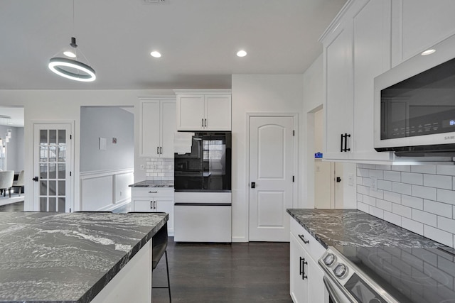 kitchen with tasteful backsplash, dark wood finished floors, dark stone counters, white cabinets, and stainless steel appliances