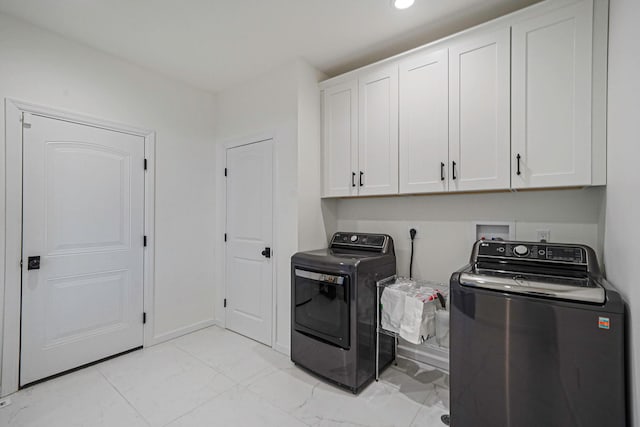 washroom with baseboards, cabinet space, separate washer and dryer, and marble finish floor