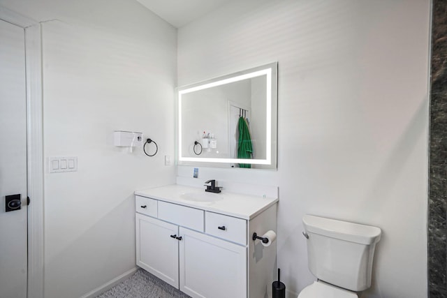 half bathroom featuring baseboards, toilet, and vanity