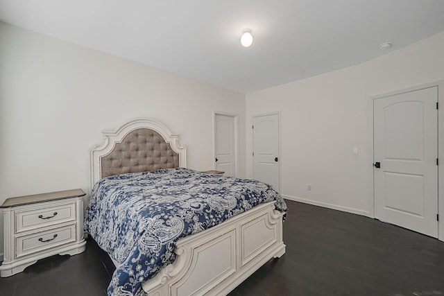 bedroom featuring baseboards and dark wood-style flooring