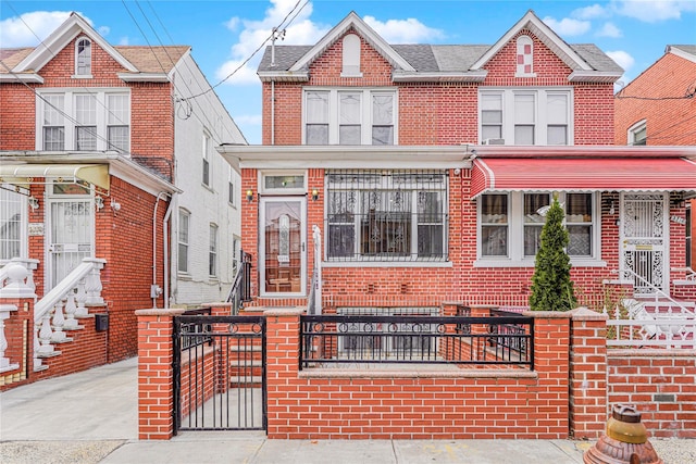 view of front of house featuring a fenced front yard and brick siding