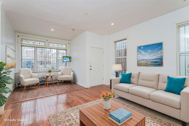 living area featuring baseboards, wood-type flooring, and recessed lighting