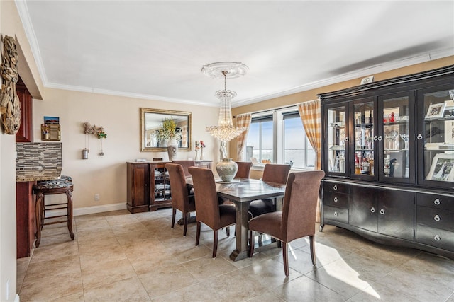 dining room featuring light tile patterned flooring, a notable chandelier, baseboards, and ornamental molding