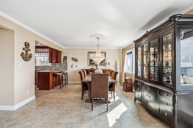 dining space with baseboards, a chandelier, light tile patterned flooring, and ornamental molding