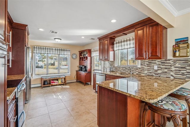 kitchen with tasteful backsplash, visible vents, light stone counters, appliances with stainless steel finishes, and a sink