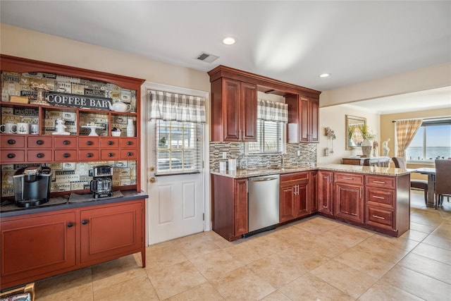 kitchen featuring dishwasher, a peninsula, plenty of natural light, and visible vents