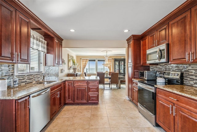 kitchen featuring a sink, plenty of natural light, appliances with stainless steel finishes, and a peninsula