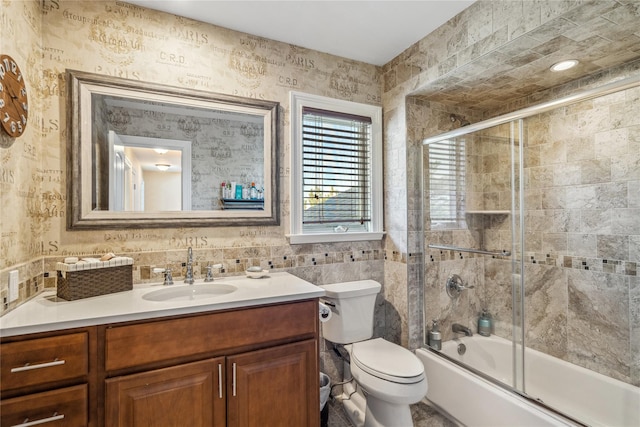 full bathroom with toilet, vanity, and bath / shower combo with glass door