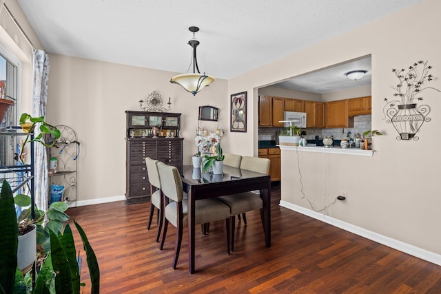 dining space with baseboards and dark wood-style flooring