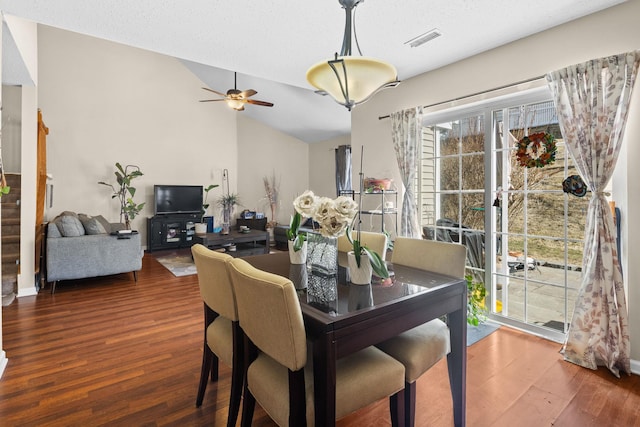 dining area with a ceiling fan, visible vents, vaulted ceiling, and wood finished floors