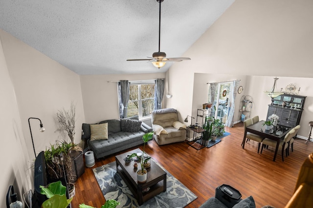 living area with a textured ceiling, a ceiling fan, vaulted ceiling, and wood finished floors