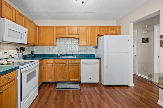 kitchen with white appliances, dark wood finished floors, dark countertops, a sink, and backsplash