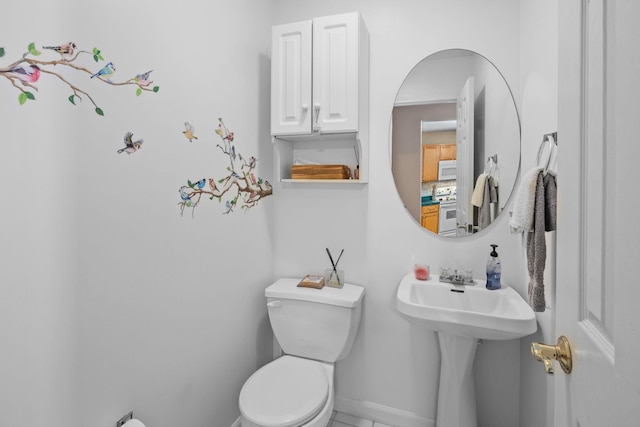 bathroom with baseboards, a sink, and toilet