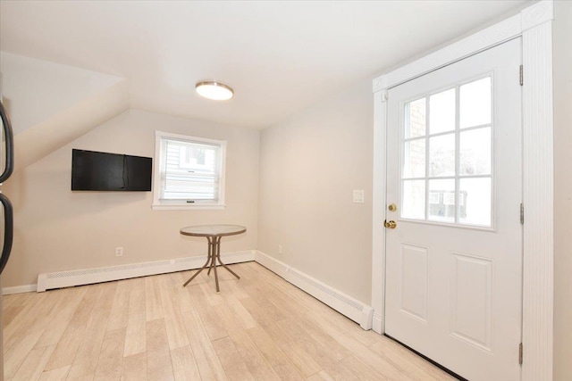 doorway to outside with lofted ceiling, baseboards, light wood finished floors, and a baseboard radiator