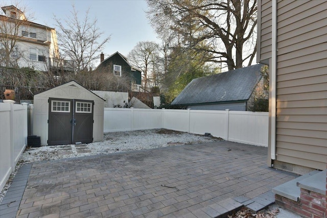 view of patio / terrace featuring a fenced backyard, an outdoor structure, and a shed