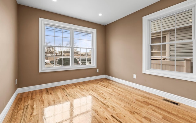 unfurnished room with baseboards, visible vents, wood finished floors, and recessed lighting