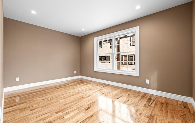 spare room featuring recessed lighting, baseboards, and wood finished floors