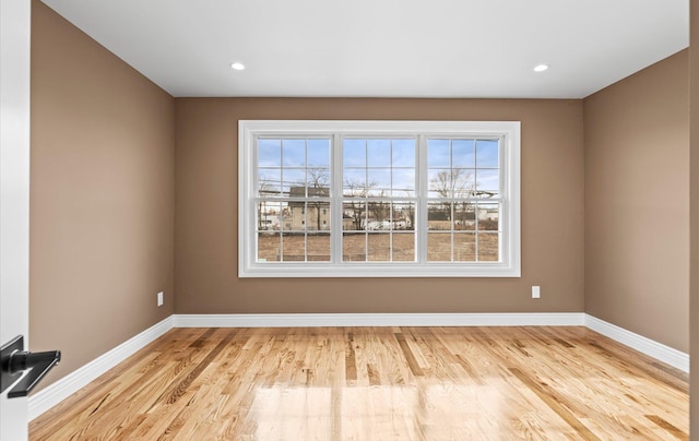 spare room with recessed lighting, light wood-type flooring, and baseboards