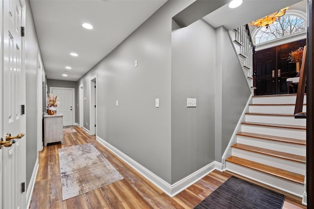 interior space featuring stairway, recessed lighting, baseboards, and light wood finished floors