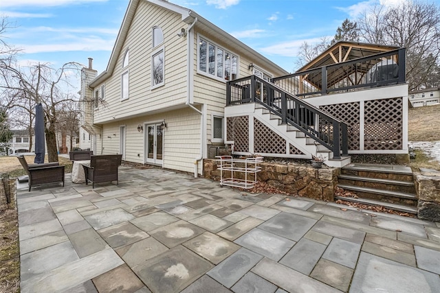 rear view of house featuring stairs, a patio area, french doors, and a wooden deck